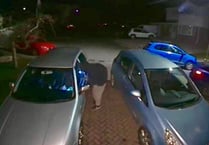 Hooded man captured on CCTV peering into cars