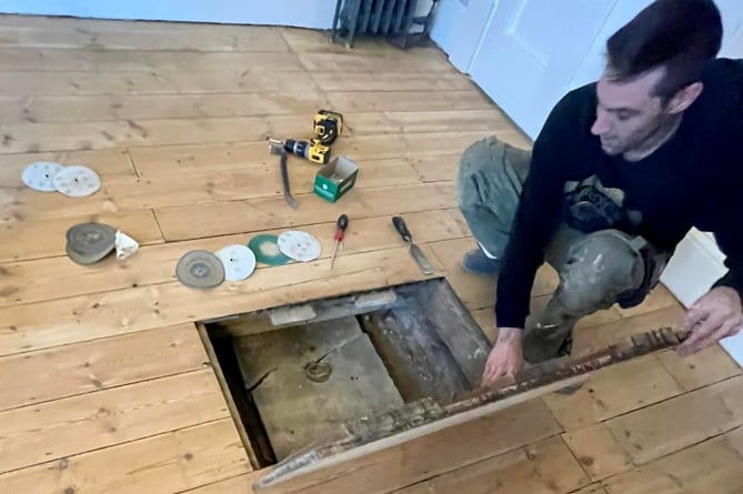 A man opening up a trap door.