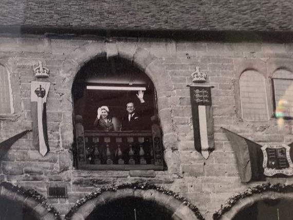 Prince Philip and Her Majesty The Queen wave to crowds from Ross-on-Wye’s Market Hall in April 1957.
