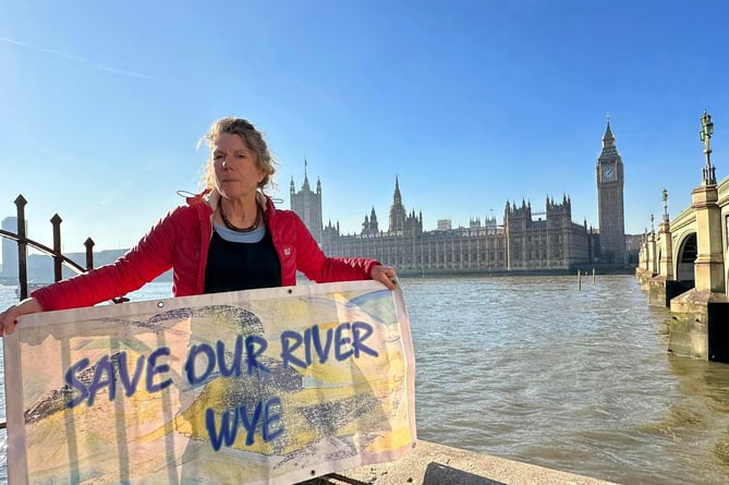 Angela Jones outside of Westminster holding a banner which reads "Save our River Wye"