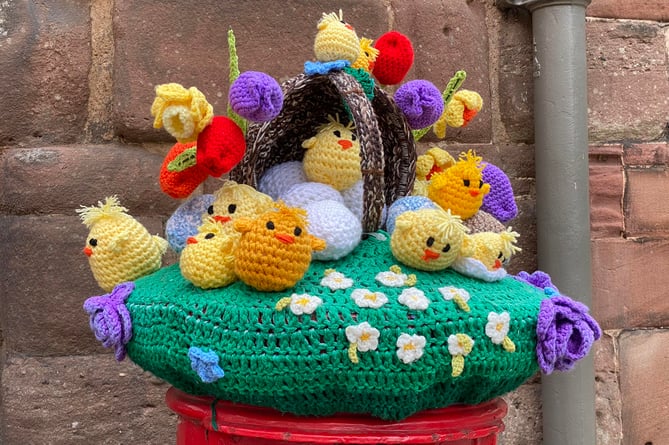 A photo of a knitted top for a postbox, featuring several cute chicks