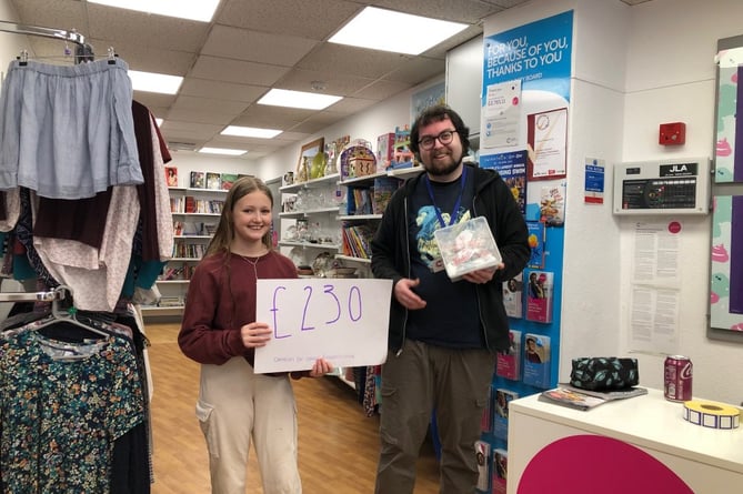 John Kyrle High School pupil giving the funds raised to Cancer Research UK