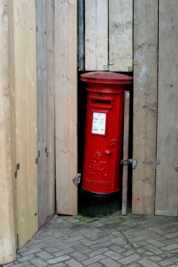Postbox surrounded by wooden planking