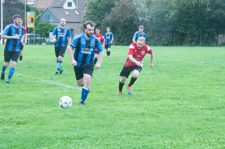 Redbrook captain Larsson Brown on the ball as Longhope defender Robbie Clark closes in.