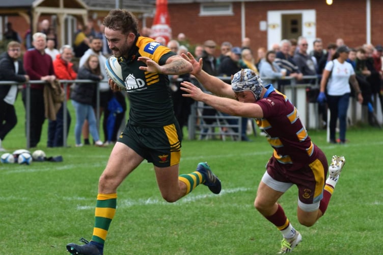 A Newent player runs in to score