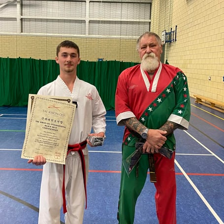 Geraint Davies Jones with his black belt award alongside Grand Master Anthony Farr