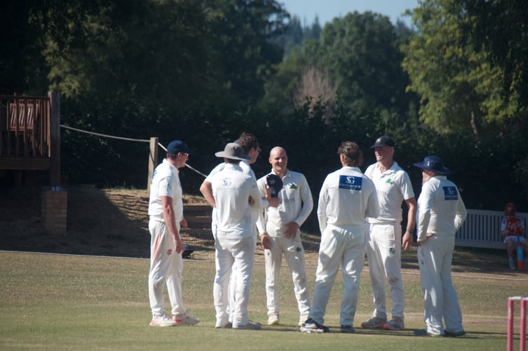 Anthony James (centre) is congratulated after taking his first wicket.