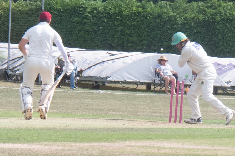 Nic Merrin takes off the balls after a throw by Oliver Henson for a run out.