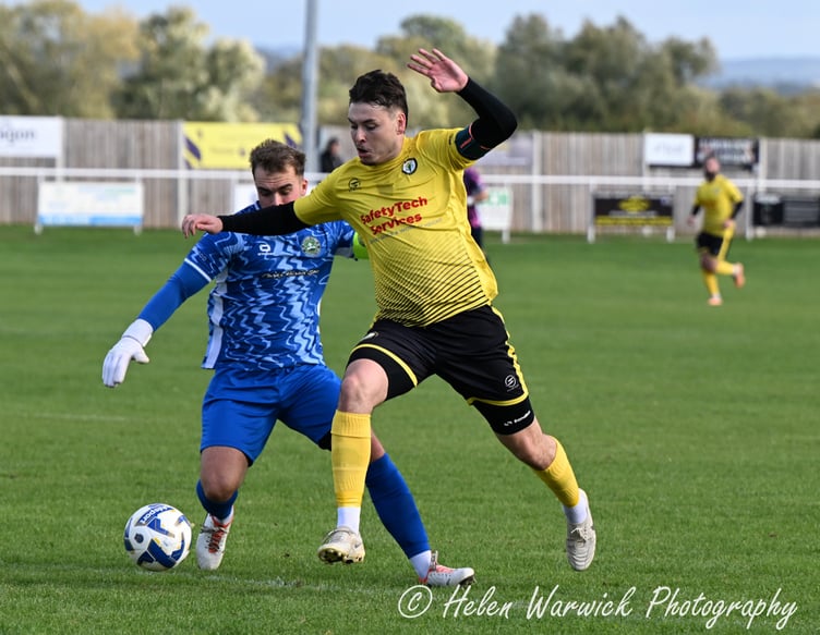 A Newent Town player rounds the keeper