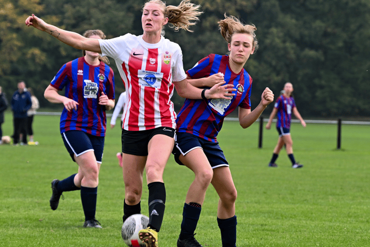 A Juniors player holds off the challenge of an opponent