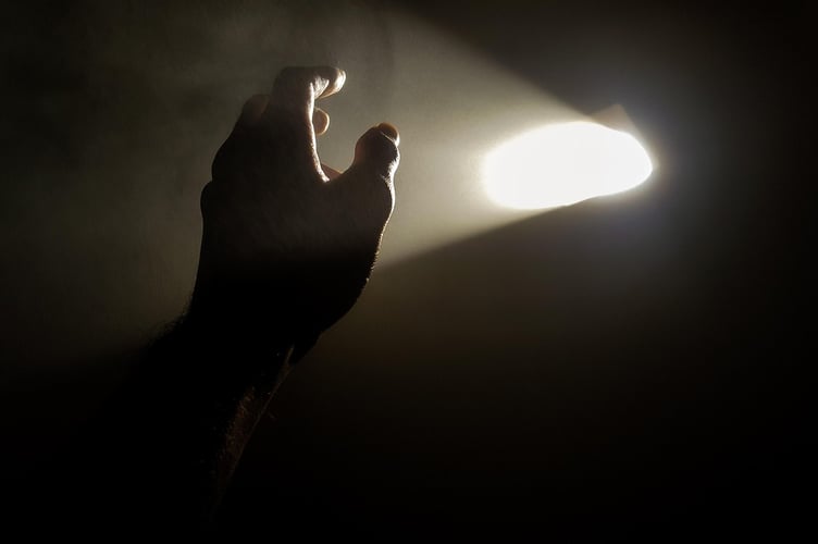 Hand reaching out to sunlight