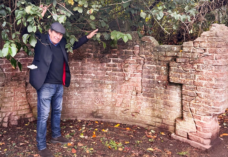 Musician Jools Holland holds back the overgrowth at the Dennis Potter Memorial Wall in Ross-on-Wye.