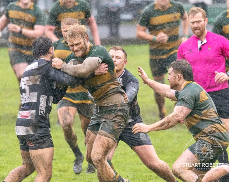 The rain pours as a Newent player takes on the Lydney defence